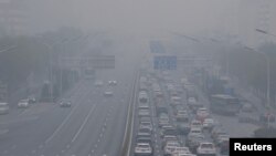 Kabut asap tebal yang menyelimuti ibu kota China setelah kota itu mengeluarkan peringatan polusi udara pertamanya untuk musim dingin, di Beijing, China 26 November 2018. (Foto: REUTERS/Jason Lee)