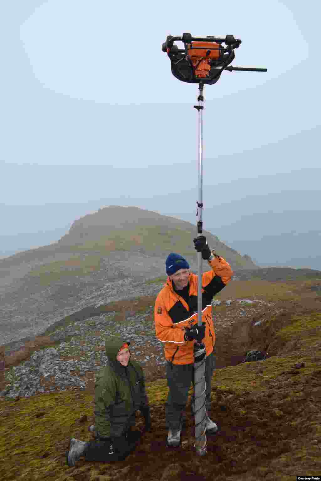 British Antarctic Survey scientists Dominic Hodson and Jessica Royles work with core sampling equipment on a high elevation moss bank on Elephant Island, South Shetland Islands. (Dan Charman/Matt Amesbury)