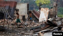 Anak-anak Rohingya mengumpulkan barang-barang yang masih bisa dipakai setelah sebuah pasar Rohingya di kota Maugndaw, Rakhine, Myanmar dibakar massa (27/10 /foto: ilustrasi).