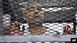 Wartawan Al-Jazeera Mohamed Fahmy, yang merupakan warga Mesir keturunan Kanada, di dalam kurungan di pengadilan Mesir, Mei 2014. 
