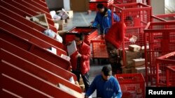 網絡銷售的幕後：商品快遞。圖為電子商務巨頭京東在北京的物流中心包裹自動分揀線上工人的工作情況。（2020年11月路透社）