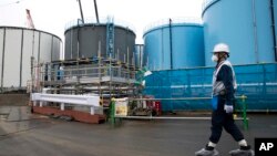 Seorang pekerja berjalan di dekat tangki-tangki untuk menyimpan air yang terkontaminasi di PLTN Fukushima (foto: dok). 