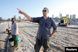 American conservation biologist and crocodile expert Matt Shirley stands near a section of the lagoon in Abidjan where a big high-end residential and commercial development is under construction, Ivory Coast, July 12, 2017.