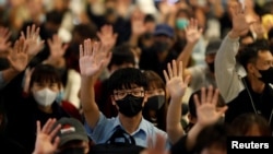 Protesters wearing face masks hold up their hands during an anti-government protest at Yoho Mall in Yuen Long, Hong Kong, China, Nov. 21, 2019. 