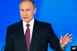 FILE - Russian President Vladimir Putin gestures as he gives his annual state of the nation address in Manezh in Moscow, Russia, March 1, 2018.