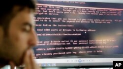 Razvan Muresan, a Bitdefender public relations specialist, is backdropped by a screenshot of the message displayed on computers affected by the latest cyberattack, in Bucharest, Romania, June 28, 2017. A new, highly virulent strain of malicious ransom so