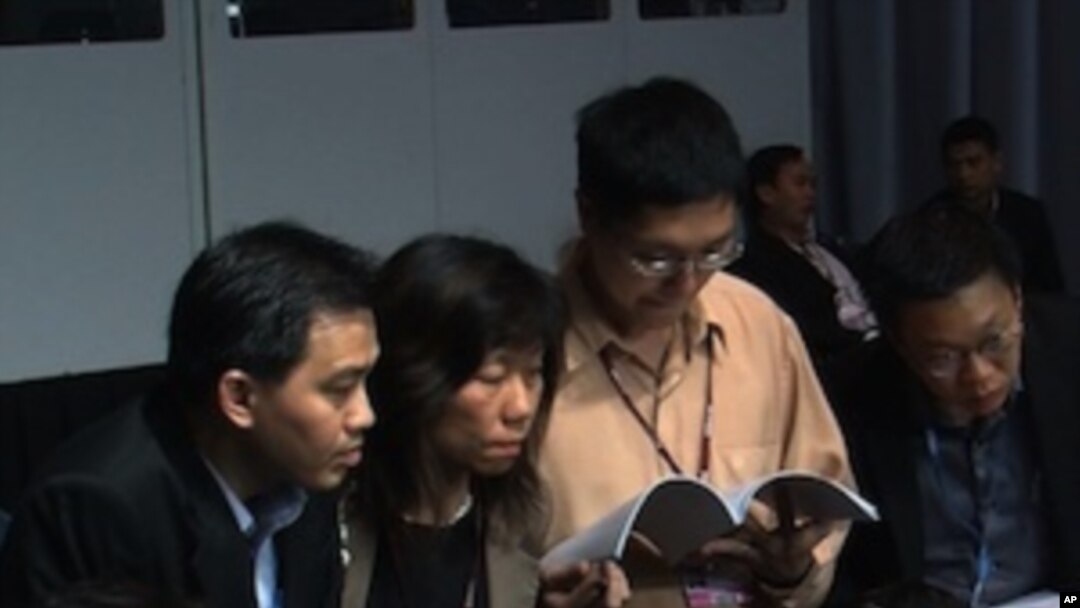 Delegates look over the final draft agreement at the UN Climate Change Conference in Cancun, Mexico