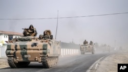 Turkish army tanks and armored personnel carriers move toward the Syrian border in Karkamis, Turkey, Aug. 25, 2016. 