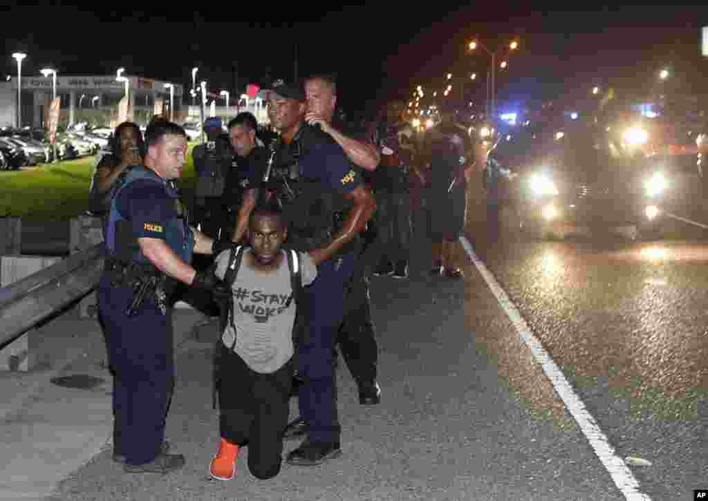 Police arrest activist DeRay McKesson during a protest along Airline Highway, a major road that passes in front of the Baton Rouge Police Department headquarters in Baton Rouge, Louisana, July 9, 2016. Protesters angry over the fatal shooting of Alton Sterling by two white Baton Rouge police officers rallied at the convenience store where he was shot.
