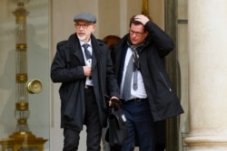 FILE - Georges Salines, left, whose daughter was killed in the 2015 Paris attacks by IS militants, and lawyer Jean Reinhart leave the Elysee Palace in Paris, after a meeting with French President Francois Hollande.