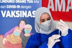 Seorang nakes mempersiapkan suntikan untuk vaksinasi COVID-19 Moderna di Barona Jaya, luar Banda Aceh, 13 Agustus 2021. (CHAIDEER MAHYUDDIN / AFP)