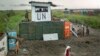 Displaced South Sudanese next to United Nations peacekeepers from Mongolia guarding the gate, at a makeshift camp at the United Nations Mission in South Sudan (UNMISS) base in the town of Bentiu, South Sudan, Sept. 22, 2014. 