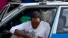 FILE - A taxi driver checks his smartphone as he waits for his customers in Addis Ababa, Ethiopia, Nov. 12, 2019.