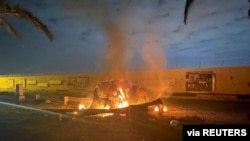 Burning debris are seen on a road near Baghdad international airport, which according to Iraqi paramilitary groups were caused by three rockets hitting the airport in Iraq, Jan. 3, 2020, in this image obtained via social media.