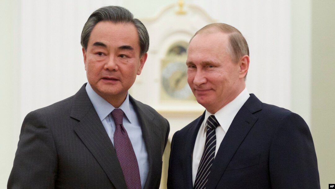 Russian President Vladimir Putin, right, shakes hands with Chinese Foreign Minister Wang Yi during their meeting in Moscow, Russia, March 11, 2016.