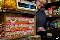 Candy store owner Sofia Rumpf attends a customer in Santiago, Chile, June 24, 2016 photo.
