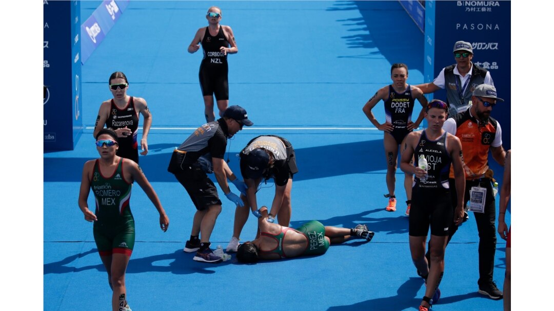 FILE - Mexico's Cecilia Perez, center, collapses after competing in a women's triathlon test event at Odaiba Marine Park, a venue for marathon swimming and triathlon at the Tokyo 2020 Olympics in Tokyo, Aug. 15, 2019.