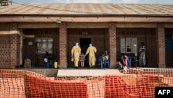 Medical workers lead a young girl with suspected Ebola into the unconfirmed Ebola patients ward run by The Alliance for International Medical Action (ALIMA), Aug. 12, 2018 in Beni, northeastern DRC.