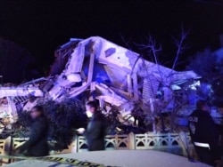 Turkish officials and police arrive at the scene of a collapsed building following a 6.8-magnitude earthquake in Elazig, eastern Turkey, Jan. 24, 2020.