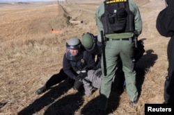 A protester is arrested next to the pipeline route during a protest against the Dakota Access pipeline near the Standing Rock Sioux Reservation in St. Anthony, N.D., Nov. 11, 2016.