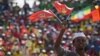 A youth waves the ruling party Ethiopian People’s Revolutionary Democratic Front (EPRDF) flag in front of a large crowd during an election rally by the EPRDF in Addis Ababa, May 21, 2015.