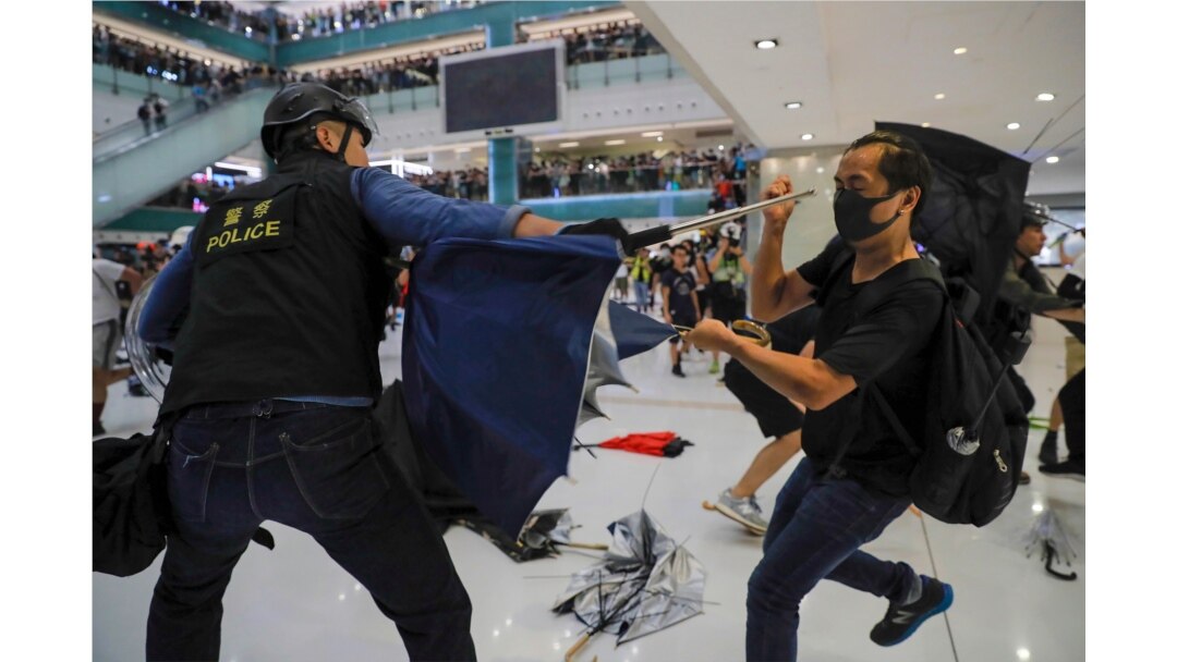 A policeman scuffles with a protester inside a mall in Sha Tin District in Hong Kong, July 14, 2019.