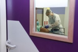 A health care worker tends to a patient infected with COVID-19 at The Hospital Martial Henry in Pamandzi, on the French Indian Ocean island of Mayotte, March 1, 2021.