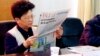 FILE - Yang Xiuzhu reads newspaper during meeting in Wenzhou, Zhejiang province, China, Dec. 29, 2001.