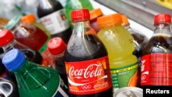 A Coca-Cola bottle is seen with other beverages in New York June 23, 2008. Beverage industry executives will gather in New York this week for a major industry conference with concerns that the rising price of corn syrup will put pressure on soda prices. R