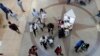 FILE- Shoppers walk through Dolphin Mall on Black Friday in Miami, Nov. 23, 2018. On Tuesday, Jan. 29, 2019, the Conference Board releases its January index on U.S. consumer confidence.