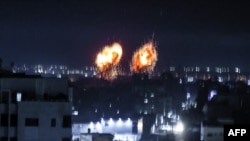 Ledakan menerangi langit malam di Kota Gaza saat pasukan Israel menembaki daerah Palestina.