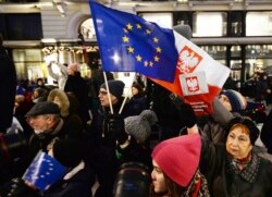 Pengunjuk rasa membawa bendera Uni Eropa pada protes anti-pemerintah di Warsawa, Polandia. Beberapa orang Polandia khawatir konflik yang berlarut-larut dengan UE mengenai anggaran dapat membuat mereka meninggalkan blok tersebut. (Foto: AP/Czarek Sokolowsk