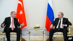 Presiden Turki Recep Tayyip Erdogan (kiri) berbicara dengan Presiden Rusia Vladimir Putin dalam pertemuan di istana Konstantin di luar kota St.Petersburg, Rusia (9/8). (AP/Alexander Zemlianichenko)