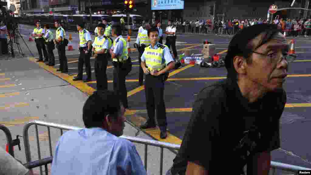 Police officers stand guard on a junction at Mongkok shopping district, where pro-democracy protesters have recaptured a main road, in Hong Kong, Oct. 20, 2014.