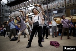 Warga lansia dan paruh baya di Jepang sedang berolahraga dalam acara promosi kesehatan memperingati “Hari Lansia” di sebuah kuil di distrik Sugamo, di Tokyo, 21 September 2015.
