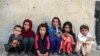 Anak-anak duduk di depan sebuah rumah di desa Deh Qubad di distrik Maiwand, Provinsi Kandahar, Afghanistan, 27 September 2020. (Foto: AFP)