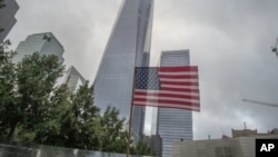FILE - An American flag is placed along the South Pool prior to a ceremony at the World Trade Center site in New York, Sept. 11, 2015.