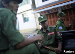 FILE - Armed soldiers from the United Wa State Army ride in a vehicle on a street in Namteuk, in Myanmar's Wa State, Sept. 3, 2009.