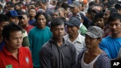 Para nelayan dari Burman menanti keberangkatan kapal yang akan membawa mereka meninggalkan Pusaka Benjina di Kepulauan Aru, 3 April 2015.