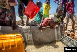 Children drink water delivered by a truck in the drought stricken Baligubadle village near Hargeisa, the capital city of Somaliland, in this handout picture provided by The International Federation of Red Cross and Red Crescent Societies on March 15, 2017