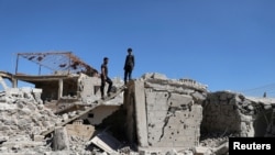 FILE - Men inspect a damaged house in Busra al-Harir, near Deraa, Syria, March 13, 2018. Russian jets struck the opposition-held town on June 24, 2018, opposition sources said.