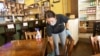 Carlee Packard wipes down a table and chairs after customers finished eating at Puckett's Grocery & Restaurant, April 27, 2020, in Franklin, Tenn. 