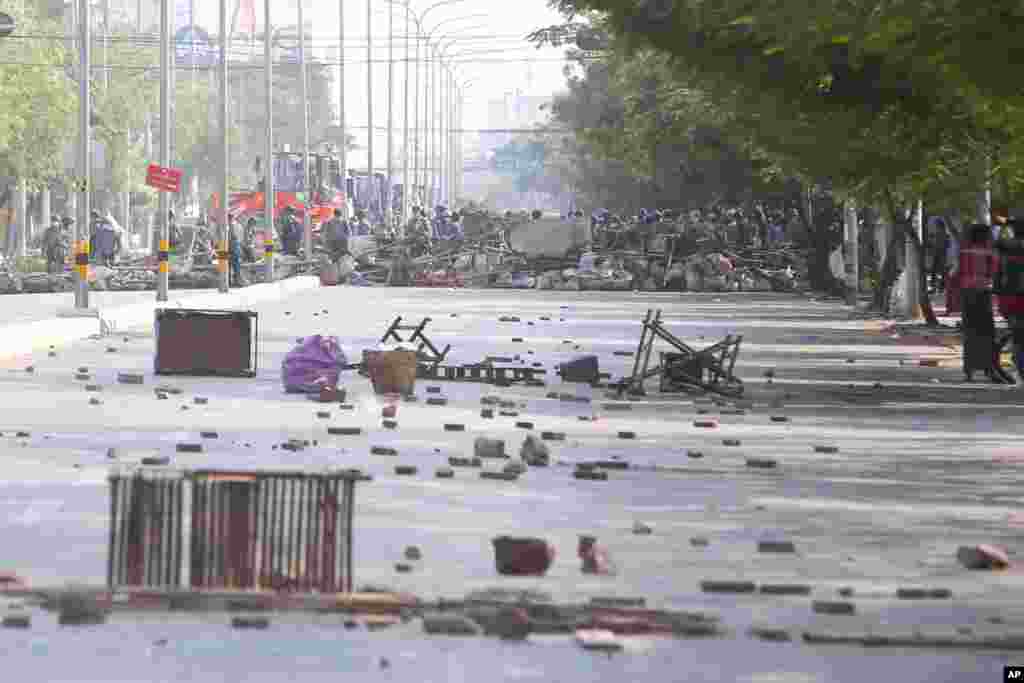 Myanmar riot police are seen behind the barricade during a protest against the military coup in Mandalay, Feb. 28, 2021.