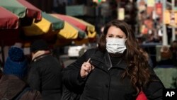 紐約一名外籍婦女說﹐戴口罩以避免感染冠狀病毒。