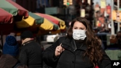 2020年1月30日，一名医药公司女职员在纽约街头行走。她说戴口罩是因为担心感染新冠状病毒。