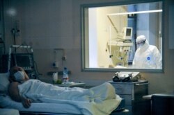 A doctor observes through a glass window the condition of the patient in a ward in the Moscow Sklifosovsky emergency hospital in Moscow, Russia, March 25, 2020.