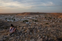 FILE - A Tigray girl sits atop a hill overlooking the Um Rakouba refugee camp, hosting people who fled the conflict in the Tigray region of Ethiopia, in Qadarif, eastern Sudan, Dec. 14, 2020.