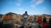 Residents stand amid houses damaged when a gasoline truck overturned and exploded in Cap-Hatien, Haiti, Dec. 14, 2021.