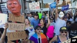 Protesters hold banners during a rally in opposition to President-elect Donald Trump, in the Hollywood section of Los Angeles, California, Nov. 13, 2016.