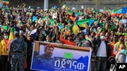FILE - People gather behind a placard showing Prime Minister Abiy Ahmed at a rally organized by local authorities to show support for the Ethiopian National Defense Force (ENDF), at Meskel square in Addis Ababa, Ethiopia, Nov. 7, 2021.